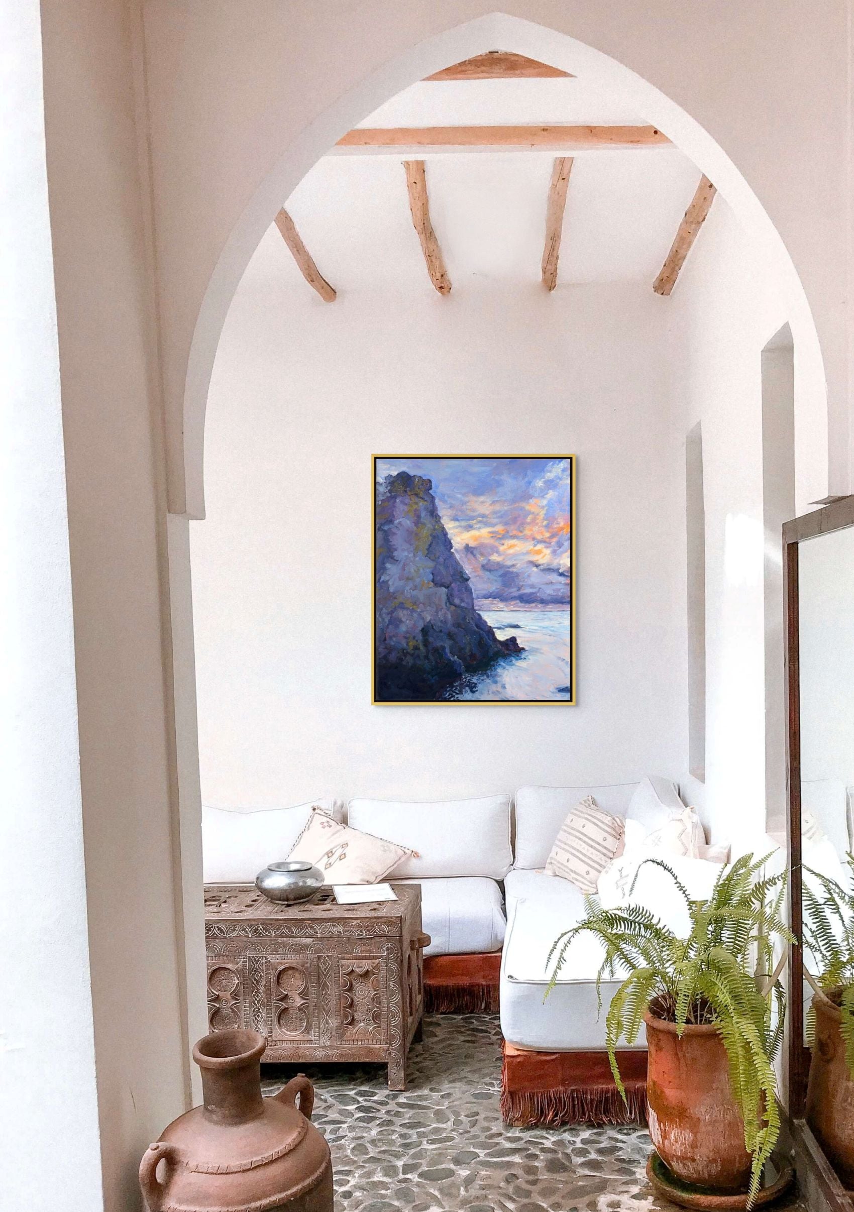 Stone Giant oil painting by Sally Herriott, solitary rauk sea stack rising from calm Baltic water at sunset, displayed in a white walled room with arched entrance way
